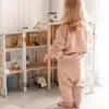 A young child is playing with a large wooden fire station and police station playset. Náhľad obrázku produktu