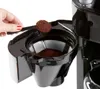 A hand is adding coffee grounds to a coffee maker. Podgląd zdjęcia produktu
