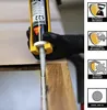 A gloved hand is using a caulking gun to apply sealant to a wooden joint. Náhľad obrázku produktu
