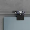 A close-up view of a sliding glass door hardware system mounted on a track against a textured gray wall. Produktbild-Vorschau