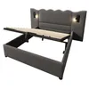 A grey upholstered bed frame with the mattress support mechanism lifted to reveal storage space underneath. Produktbild-Vorschau
