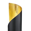 Close-up of a table lamp with a black exterior and a gold interior. Voir les images du produit