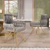 Two gray velvet dining chairs with gold legs are shown in a dining room setting. Náhled obrázku produktu