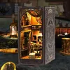 A miniature 3D model of a library or study, illuminated by warm lights, set against a dark, textured background with other decorative items. Náhľad obrázku produktu