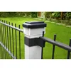 A close-up of a fence post with a solar light on top, in a garden setting. Produktbild-Vorschau