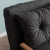 A close-up view of a dark gray tufted cushion on a sofa. Náhled obrázku produktu