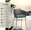 A chair with cushions on a patio with a pool and ocean in the background. Produktbild-Vorschau