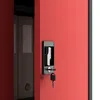 A close-up view of a red metal cabinet door with a black handle and a key inserted into the lock. Voir les images du produit