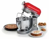 A red and silver stand mixer is shown with baked goods, including a cake and cookies, arranged around it. Podgląd zdjęcia produktu