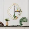 A decorative mirror hangs on a wall above a desk in a home office setting. A green chair and a laptop are visible on the desk. Produktbild-Vorschau