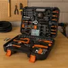 A tool kit is open and displayed on a wooden surface, with a pegboard and tools in the background. Produktbild-Vorschau