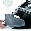 A hand is pouring water into the water tank of a steam iron. Produktbild-Vorschau