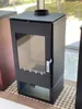 A black wood-burning stove with a glass door is displayed indoors, possibly in a showroom or home. Produktbild-Vorschau