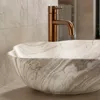 A close-up view of a marble basin with a bronze faucet. Anteprima dell’immagine prodotto
