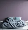 A bedroom scene with a bed and a purple wall. Podgląd zdjęcia produktu