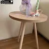 A small round wooden side table with decorative items on top. Produktbild-Vorschau