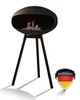 A black bioethanol fireplace on a tripod stand, with flames burning inside. A German flag emblem is in the bottom right corner. Podgląd zdjęcia produktu