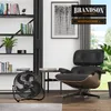 A modern living room with a black fan in the foreground, a black leather chair, and a bookshelf. Anteprima dell’immagine prodotto