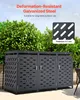 A dark gray, three-unit trash can enclosure with a perforated design, set against a backdrop of lush green bushes. Produktbild-Vorschau