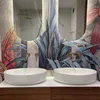 A modern bathroom with two white vessel sinks and a tropical-themed wallpaper. Produktbild-Vorschau