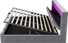 A bed frame with its mattress support mechanism lifted to reveal storage space underneath. LED lighting is visible at the headboard. Produktbild-Vorschau