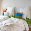 A bed with multiple pillows and duvets, arranged for display. Produktbild-Vorschau