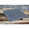 A cast iron grate is placed on a pile of logs, with dimensions and model information overlaid. Voir les images du produit