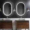 A modern bathroom with two oval mirrors above two wooden vanities. Produktbild-Vorschau
