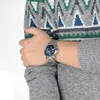 A person wearing a sweater and a watch. Voir les images du produit