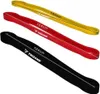 Three resistance bands of different colors are laid out diagonally on a white background. Produktbild-Vorschau