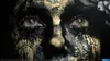 Close-up of a person's face with black and gold paint on it, focusing on the eyes. Produktbild-Vorschau