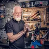 A man in a workshop is cleaning his hands with a rag. Produktbild-Vorschau