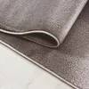 A close-up view of a rolled-up rug on a light-colored wooden floor. Produktbild-Vorschau