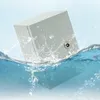 A gray metal junction box is partially submerged in water, with water splashing around it. Náhled obrázku produktu