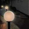 A pathway lined with globe-shaped garden lights at night. Voir les images du produit
