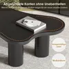 A close-up of a black coffee table with a book and phone on it, set on a carpeted floor. Voir les images du produit