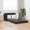 A black sofa bed with white pillows and a white throw blanket is shown in a room with wooden floors, a window with blinds, and a potted plant. Anteprima dell’immagine prodotto