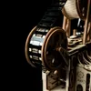 A close-up shot of a wooden model film projector with film reel. Produktbild-Vorschau