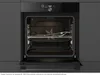 An open built-in oven with racks and a baking tray inside. Voir les images du produit