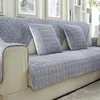 Grauer gesteppter Fleece-Sofabezug und passende Wurfkissen auf einem hellbeigen Sofa im Wohnzimmer Náhľad obrázku produktu