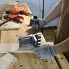 A person wearing protective gloves is using a jig to drill holes in a piece of wood on a workbench. Náhľad obrázku produktu