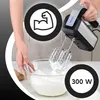 A person is using a hand mixer to whip cream in a glass bowl. Produktbild-Vorschau