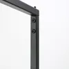 A close-up view of the black metal frame of a clothing rack, showing two screws connecting two parts of the frame. Produktbild-Vorschau