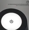 Close-up of a black lamp with a white illuminated surface featuring a power button icon. Produktbild-Vorschau