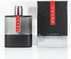 A bottle of Prada Luna Rossa Carbon Eau de Toilette and its packaging are displayed side-by-side on a white background. Podgląd zdjęcia produktu