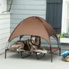 A dog is resting on an elevated pet bed with a canopy on a patio. Produktbild-Vorschau