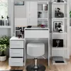 A white vanity table with drawers and a stool, set up in a room with a window and shelves. Náhled obrázku produktu