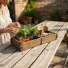 A person is preparing ingredients on a wooden table outdoors. Podgląd zdjęcia produktu