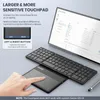 A hand is shown interacting with a large touchpad next to a foldable keyboard, with a laptop screen in the background. Produktbild-Vorschau