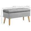 A gray storage bench with wooden legs, shown with dimensions indicated by lines and text. Náhled obrázku produktu